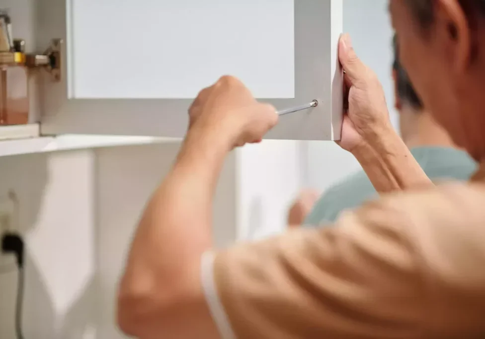 Cabinet-Coatings-Man-Tightening-Screws-on-Cabinet_2023-05-11-000021_vcwf_a8c38b