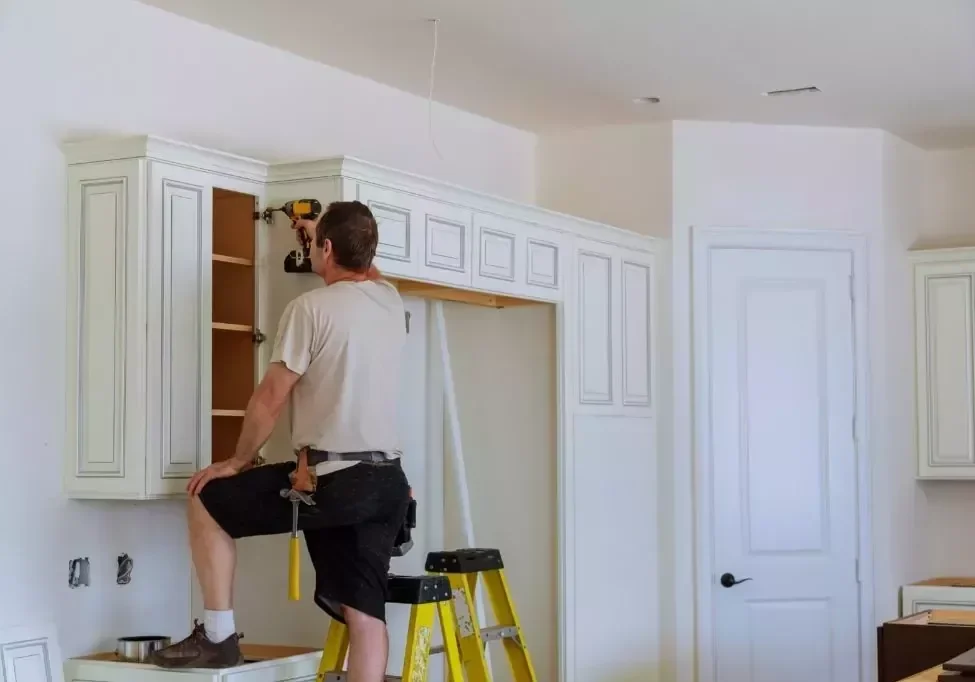 worker-installs-doors-to-kitchen-cabinet-installat-VESWPZU-1024x683_a8c38b